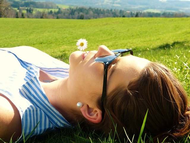 slunící se žena v trávě
